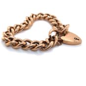 A 9ct ROSE GOLD CURB CHARM BRACELET COMPLETE WITH PADLOCK AND SAFETY CHAIN. WEIGHT 18.2grms.