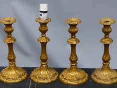 A SET OF FOUR GILT METAL CANDLESTICK TABLE LAMPS WORKED WITH ROCOCO FLOWERS AND FOLIAGE. H 32cms.
