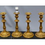 A SET OF FOUR GILT METAL CANDLESTICK TABLE LAMPS WORKED WITH ROCOCO FLOWERS AND FOLIAGE. H 32cms.