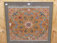 A CHINESE OCHRE GROUND SILK WOVEN PANEL WITH THE CENTRAL LOTUS FLOWER ROUNDEL ENCLOSED BY
