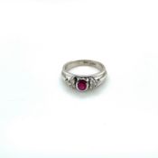 A 14ct WHITE GOLD HALLMARKED RUBY AND DIAMOND CONTEMPORARY RING. THE OVAL CUT RUBY IN A RUBOVER