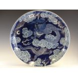 A CHINESE BLUE AND WHITE DISH, THE DRAGON AMONGST CLOUDS PICKED OUT IN WHITE AGAINST THE BLUE