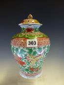 AN EARLY CHINESE JAR AND COVER PAINTED IN RED, GREEN AND YELLOW WITH BUDDHIST LIONS FROLICKING