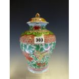 AN EARLY CHINESE JAR AND COVER PAINTED IN RED, GREEN AND YELLOW WITH BUDDHIST LIONS FROLICKING