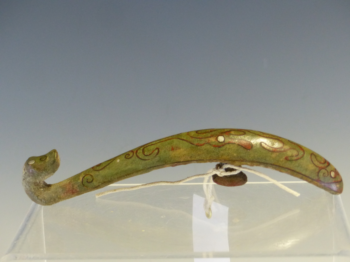 AN EARLY CHINESE BRONZE BELT HOOK, THE DRAGON FORM INLAID WITH COPPER WIRE AND SILVER STIPPLES.