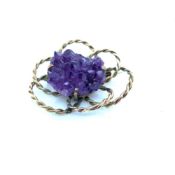 A VINTAGE HAND MADE AMETHYST CRYSTAL BROOCH IN AN OPEN WORK WOVEN SETTING. UNHALLMARKED, ASSESSED AS