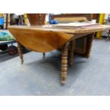 A 19th C. FRENCH WALNUT OVAL FLAP TOP TABLE SUPPORTED ON TRIPLE BALUSTER TURNED LEGS ON BRASS CASTER