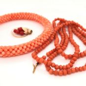 A ROW OF VINTAGE GRADUATED CORAL BANGLE TOGETHER WITH A CORAL BANGLE, AND A PENDANT OF RED GRAPES,