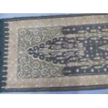 AN INDIAN GREY CLOTH PANEL SEWN IN GOLD AND COLOURED SILK THREAD WITH TWO PINE TREE SHAPES BETWEEN