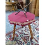 A BLOND WOOD GYPSY TABLE WITH RED CLOTH COVERED OCTAGONAL TOP AND THREE BOBBIN TURNED LEGS. W 52 x D