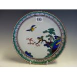 A JAPANESE GREEN KUTANI DISH CENTRALLY PAINTED WITH THREE BIRDS ABOUT A CHERRY BLOSSOM BRANCH,