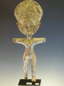 AN ASHANTI CARVED WOOD FERTILITY DOLL STANDING WITH ARMS OUT STRETCHED, THE SURFACE APPLIED WITH