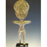 AN ASHANTI CARVED WOOD FERTILITY DOLL STANDING WITH ARMS OUT STRETCHED, THE SURFACE APPLIED WITH