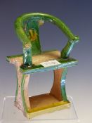 A CHINESE POTTERY CHAIR, THE HOOP BACK GLAZED IN GREEN, THE SEAT SUPPORTED ON WAISTED PLANK SIDES ON