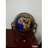 A HARDSTONE INLAID TERRESTRIAL GLOBE ON METAL STAND.