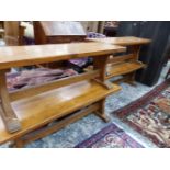 A SET OF FOUR ELM BENCHES, THE PILASTER ENDS ON BAR FEET, EACH. W 122 x d 40 x H 45cms.