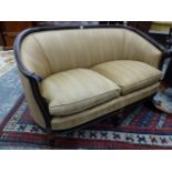 A LATE VICTORIAN EBONISED MAHOGANY SHOW FRAME TWO SEAT SETTEE, THE TOP RAIL CURVING INTO THE ARMS,