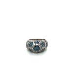 A BLUE AND WHITE DIAMOND BOMBE RING. THE BLUE DIAMONDS CREATING FLORAL CLUSTERS AMONGST THE ROUND