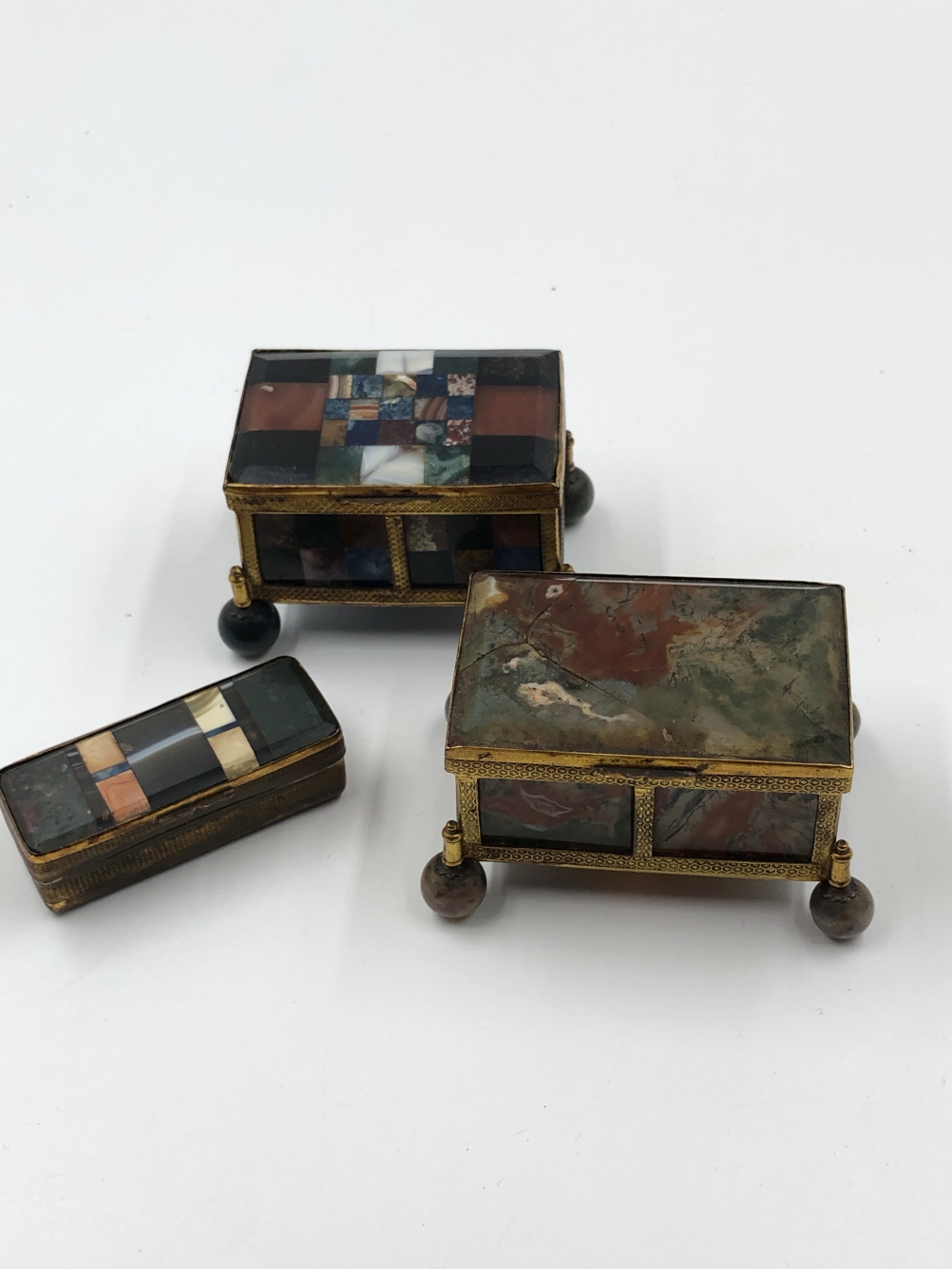 A 19th C. PIETRA DURA BOX, THE CHEQUER BOARD INLAY ABOVE FOUR BALL FEET. W 7cms. A RED AND GREEN