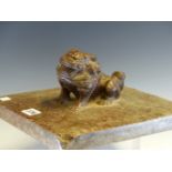 A CHINESE PUDDING STONE WEIGHT CARVED AS A LION SEATED ON A SQUARE PLINTH. 26.5 x 26cms.