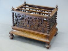 A VICTORIAN WALNUT THREE COMPARTMENT CANTERBURY WITH PIERCED SCROLL SIDES ABOVE A DRAWER AND THE