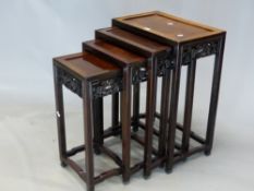 A NEST OF FOUR CHINESE HARDWOOD TABLES, EACH WITH APRONS PIERCED AND CARVED WITH DRAGONS