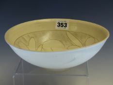 A CIZHOU WHITE GLAZED POTTERY BOWL INCISED WITH TWO FLOWER HEADS ON A COMBED GROUND. Dia. 20.5cmas.
