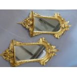 A PAIR OF LATE VICTORIAN ROUND ARCH WALL MIRRORS IN GILT GESSO AND CARVED WOOD FRAMES CRESTED BY FE