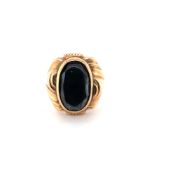 A VINTAGE STONE SET POSSIBLY HEMATITE ORNATE SIGNET RING. UNHALLMARKED, ASSESSED AS 15ct GOLD.