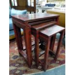 A NEST OF FOUR CHINESE RED LACQUER TABLES INCISED AND PAINTED WITH FIGURES IN LANDSCAPES