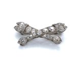 AN ANTIQUE DIAMOND SET BAR BROOCH DEPICTING CROSSED TORCHES, UNHALLMARKED ASSESSED AS PLATINUM