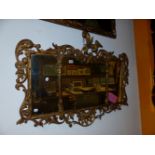 A TRIPLE PLATE MIRROR WITHIN A CARVED GILTWOOD FRAME PIERCED WITH FOLIAGE ABOUT ROCAILLE, THE SI