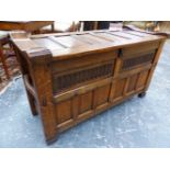 A NIGEL GRIFFITHS OAK COFFER WITH SIX PANELLED LID AND FRONT, THE NARROW SIDES WITH BAR HANDLES. W