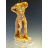 A TWO TONE ALABASTER LAMP CARVED AS A FIGURE OF ATLAS SUPPORTING A GLOBE SHADE ON HIS SHOULDERS,