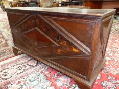 AN EARLY OAK COFFER, THE FRONT INLAID WITH A DIAMOND SHAPED BAND OF FLOWERS AND FOLIAGE ABOVE THE