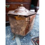 AN ARTS AND CRAFTS BRASS HANDLED COPPER HEXAGONAL COAL BUCKET AND COVER, THE BODY RAISED ON THREE