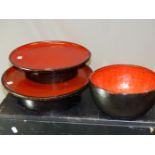 TWO JAPANESE LACQUER STANDING DISHES WITH CIRCULAR RED TOPS AND WITH BLACK RIMS AND FLARED