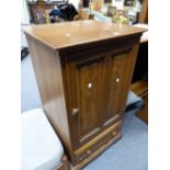 AN ERCOL ELM CUPBOARD, THE TWIN PANELLED DOOR ENCLOSING ADJUSTABLE SHELVES ABOVE A DRAWER. W 55 x