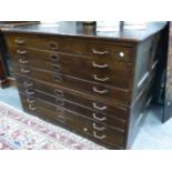 A VINTAGE STAINED PINE PLAN CHEST IN TWO PARTS, EACH WITH FOUR DRAWERS. W 126 x D 90 x H 90cms.