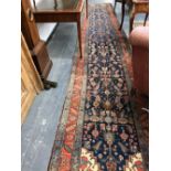 AN ANTIQUE PERSIAN HERIZ RUNNER. HARVEY NICHOLS LABEL. 565 x 103cms