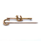 AN ANTIQUE 15ct GOLD HORSESHOE STICK PIN, AND AN ANTIQUE 9ct GOLD HORSESHOE AND RIDING CROP BAR
