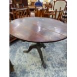 A 19th C. OAK BREAKFAST TABLE, THE CIRCULAR TOP ON A BALUSTER COLUMN AND THREE LEGS. Dia. 104 x H