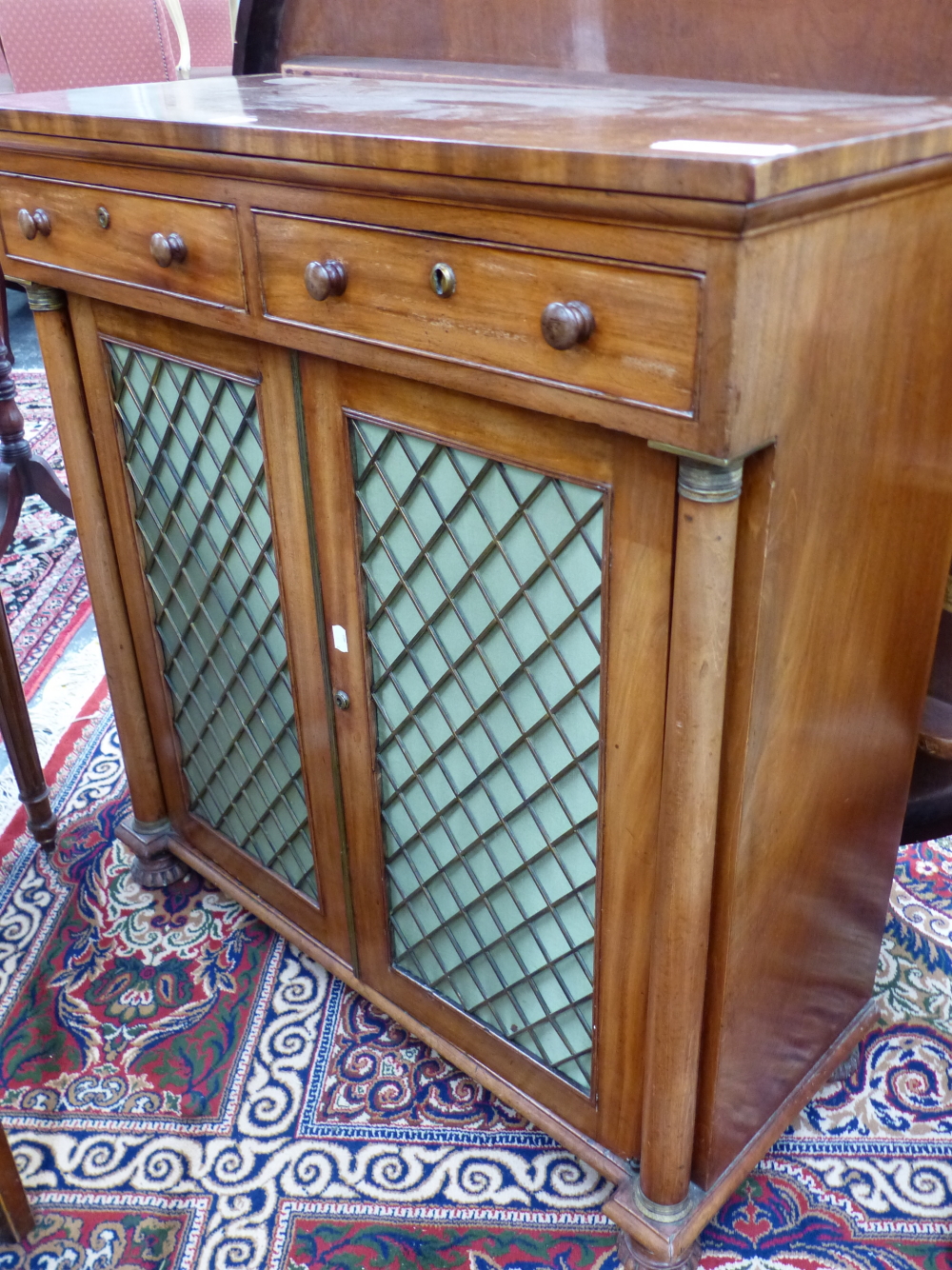 A REGENCY MAHOGANY SIDE CABINET WITH TWO DRAWERS ABOVE THE GRILLE FRONTED DOORS BETWEEN GUN BARREL