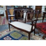 AN EDWARDIAN MAHOGANY AND INLAID SALON SETTEE.