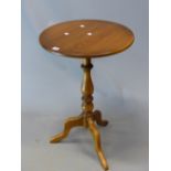 AN ERCOL ELM WINE TABLE, THE CIRCULAR TOP ON COLUMN AND TRIPOD. Dia. 50 x H 75cms.