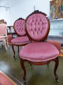 A PAIR OF VICTORIAN MAHOGANY SIDE CHAIRS WITH FLOWER CRESTED BUTTON UPHOLSTERED OVAL BACKS, THE