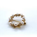 AN 18ct HALLMARKED GOLD PEARL AND DIAMOND WREATH BROOCH. DATED 1990, BIRMINGHAM. DIAMETER 2.5cms.