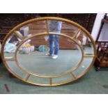 A REGENCY STYLE MARGINAL OVAL GILT FRAMED MIRROR