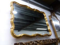 A 20th C. ITALIAN MIRROR IN A GILT WAVY RECTANGULAR FRAME CORNERED BY TREFOILS. 85 x 120cms.