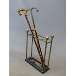 A 19th C. BRASS AND IRON STICK STAND TOGETHER WITH THREE WALKING STICKS, ONE WITH A WHITE METAL